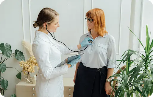 Kobieta poddawana jest badaniu przez lekarza w szpitalu.