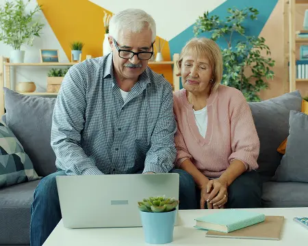 Starsza para patrzy w ekran laptopa