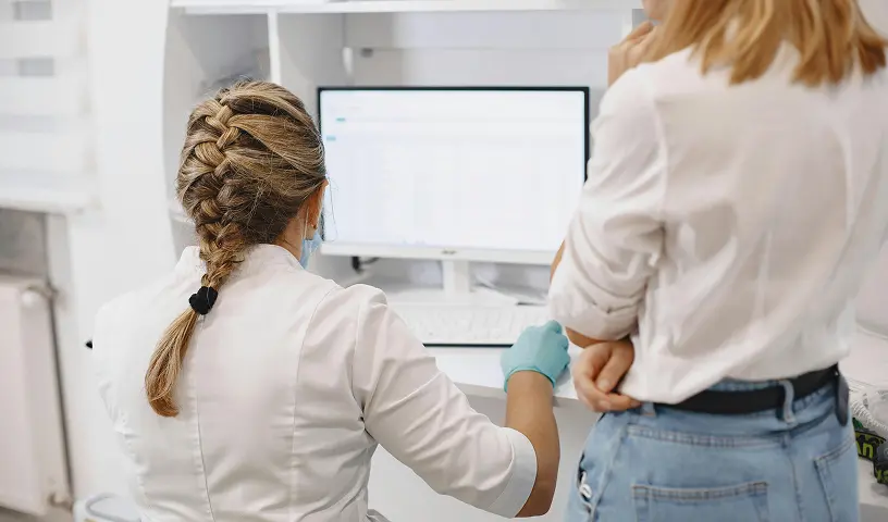 Lekarka badajaca pacjentke aparatem ultrasonograficznym w gabinecie diagnostycznym